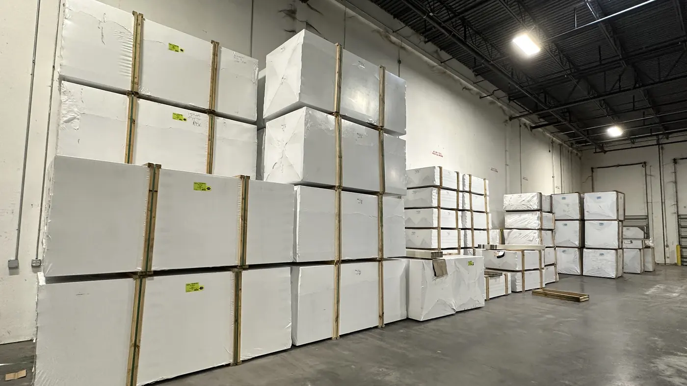 Vinyl fence panels stacked on the racks inside the Florida Fence Wholesale yard